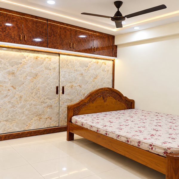Modern bedroom, contemporary bedroom, bedroom interior, gray wardrobe, marble finish wardrobe, built in wardrobe, sliding wardrobe, wardrobe design, bedroom storage, master bedroom, Indian bedroom design, modern Indian home, wooden bed, platform bed, king size bed, queen size bed, bedside cabinet, bedroom furniture, gray marble texture, brown wood panel, wardrobe shutters, sliding doors, large wardrobe, built in storage, wall mounted wardrobe, bedroom cabinets, modern cabinetry, ceiling fan, false ceiling, LED strip lighting, recessed lighting, ambient lighting, warm lighting, glossy floor tiles, white tiled floor, curtain design, gray curtains, window treatment, residential bedroom, spacious bedroom, minimalist bedroom, neutral bedroom, luxury bedroom, elegant bedroom, contemporary home, home interior design, interior decor, home furnishing, modern furniture, custom wardrobe, bespoke wardrobe, wardrobe storage, bedroom organization, functional storage, clean lines, neutral color palette, brown and gray interior, wood and marble, modern architecture, residential interior, apartment bedroom, home renovation, bedroom makeover, interior inspiration, home decor ideas, stylish bedroom, premium bedroom design, designer wardrobe, wardrobe interior, sliding door wardrobe, marble laminate, decorative panel, cabinet handles, storage cabinets, bedroom lighting, ceiling design, fan design, comfortable bedroom, practical bedroom, sophisticated decor, modern styling, uncluttered bedroom, functional interior, Indian interior design, house interior, luxury home decor, contemporary styling, polished flooring, elegant wardrobe, large storage, custom cabinetry, bedroom storage solutions, modern home styling, residential design, bedroom photography, premium interiors, warm neutral palette, modern bedroom furniture, spacious home, clean bedroom design.